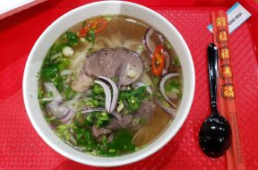 Tô phở bò nước trong với thịt bò chín và hành lá