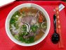 Tô phở bò nước trong với thịt bò chín và hành lá
