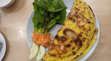 Chiếc bánh xèo vàng giòn ăn kèm rau sống và dưa leo