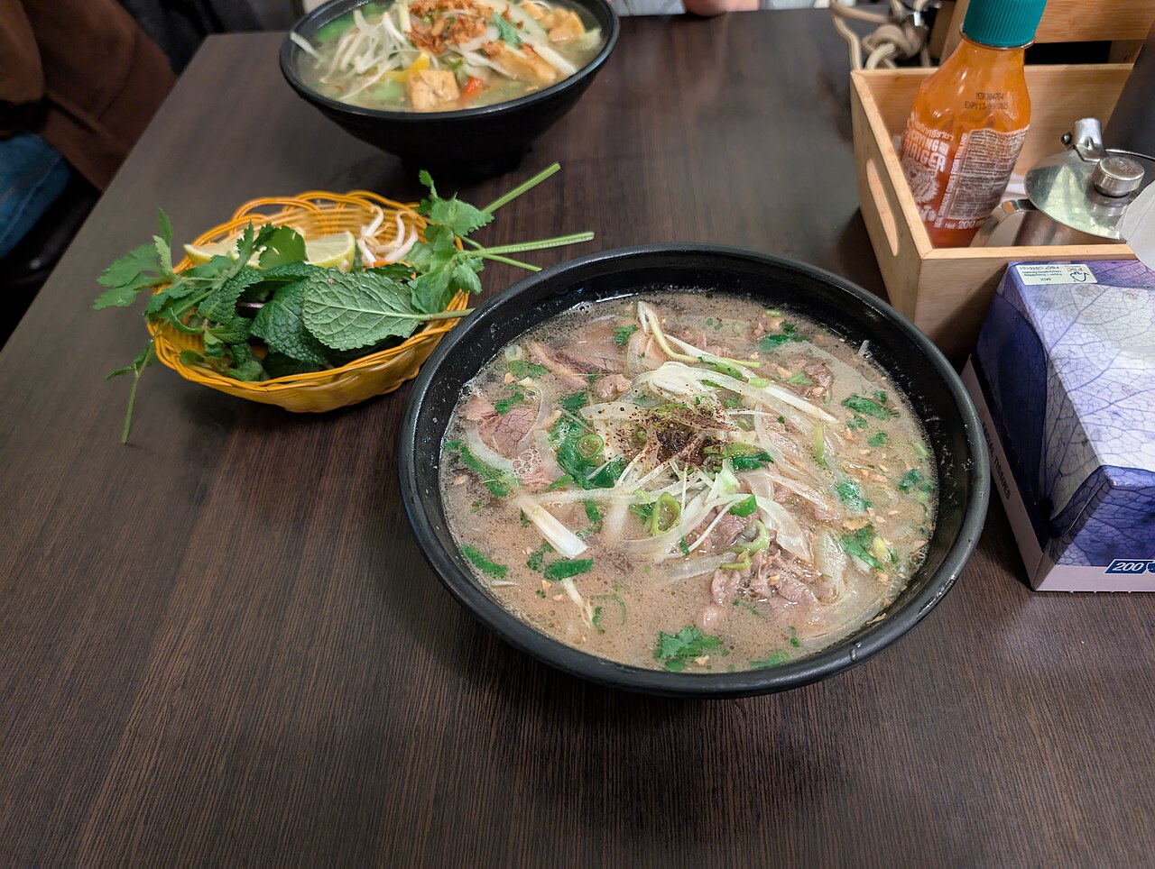 Tô phở bò nước dùng trong ăn kèm rau thơm